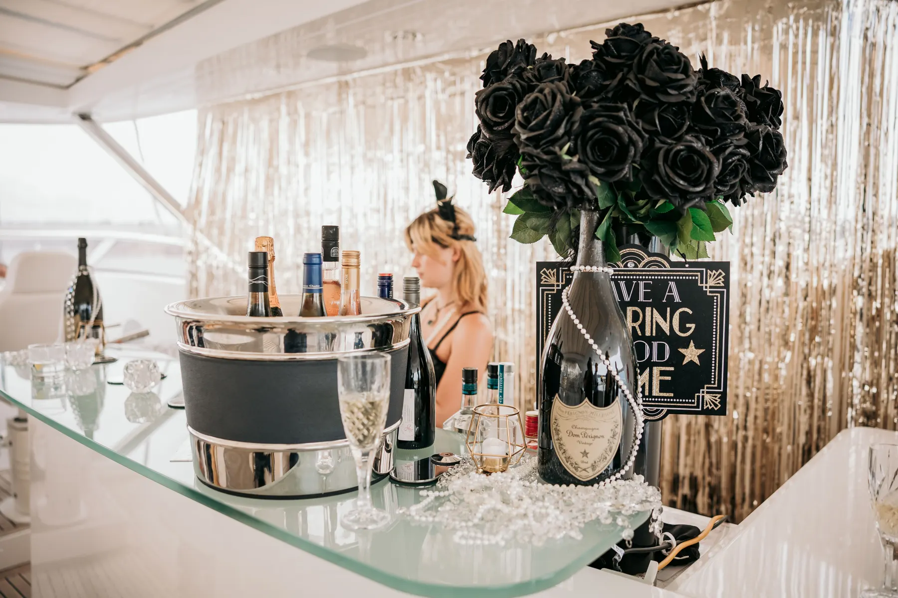 The yacht's bar set for the night: champagne on ice, black roses and gold tinsel