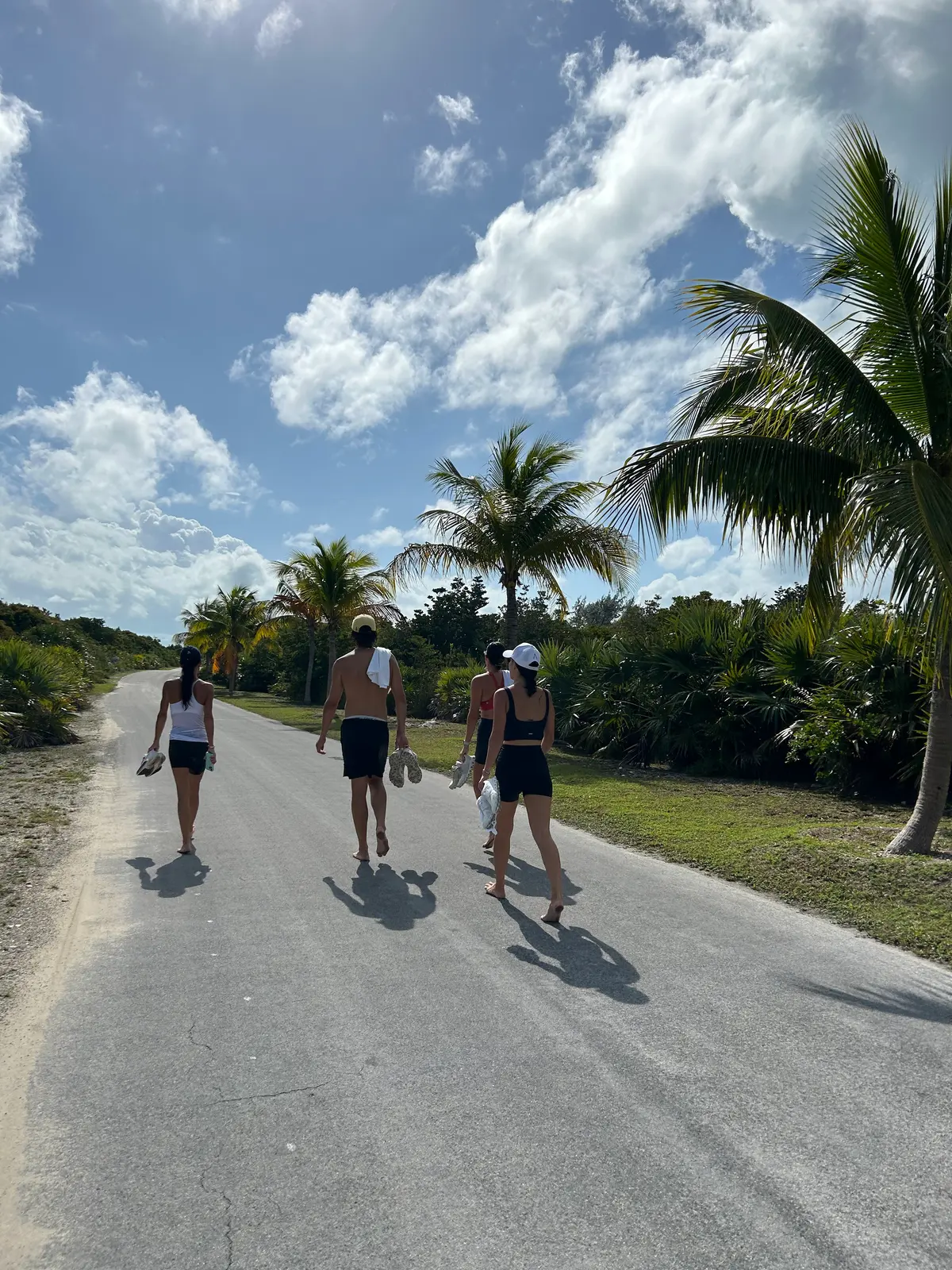 Walking barefoot along the island road, shoes in hand