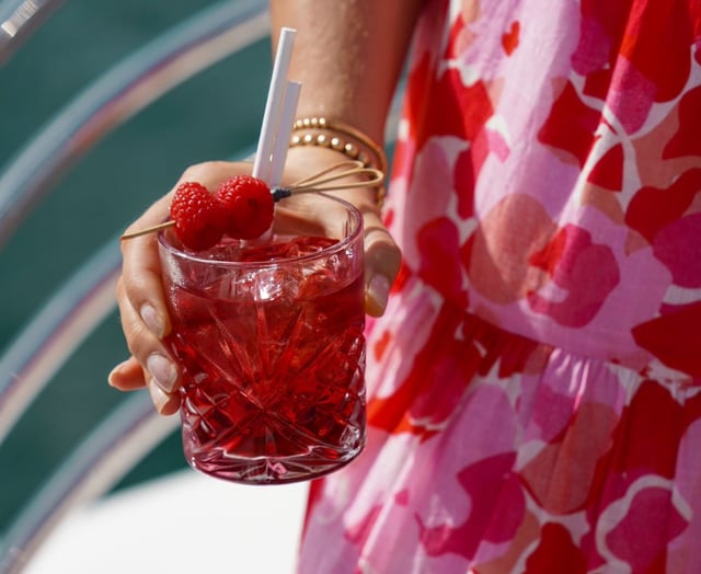 woman holding raspberry cocktail onboard a superyacht