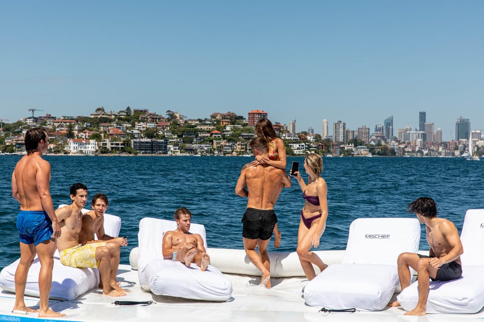 Group of people lounging on mischief yacht swim platform