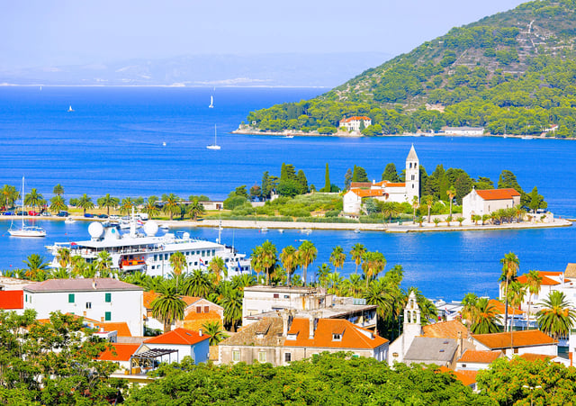 Aerial view on Prilovo peninsula with Franciscan monastery and city and port with passenger ferry which connects Split and Vis