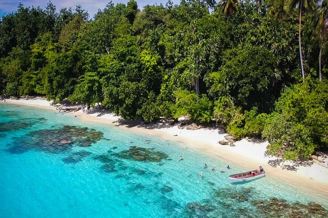 A boat and some tourist swimming in Madang, Papua New Guinea